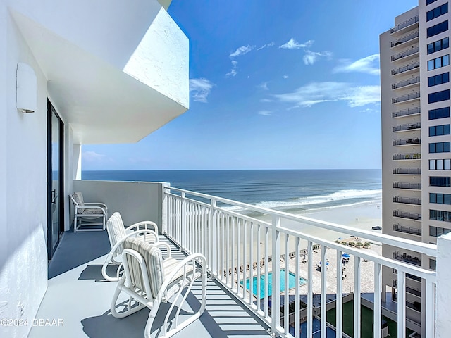 balcony featuring a beach view and a water view