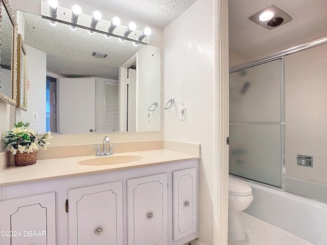 full bathroom featuring tile patterned flooring, enclosed tub / shower combo, a textured ceiling, vanity, and toilet