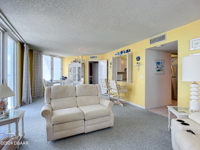 carpeted living room featuring an inviting chandelier and a textured ceiling