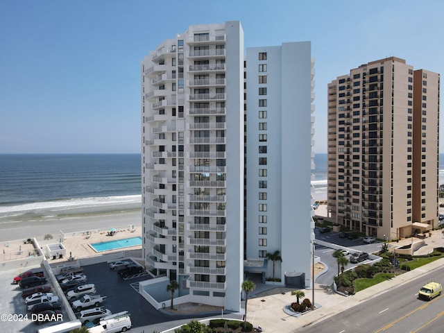 view of building exterior featuring a water view and a view of the beach