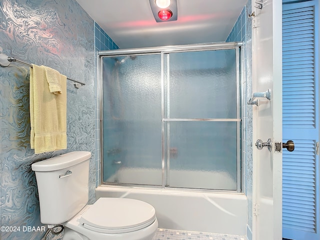 bathroom featuring combined bath / shower with glass door and toilet