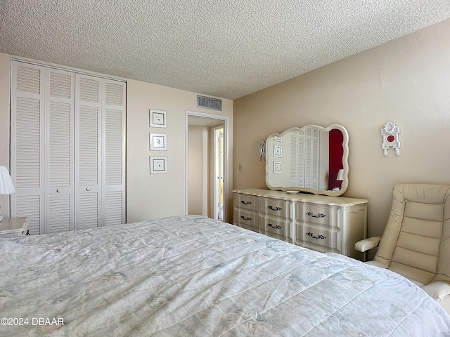 bedroom featuring a textured ceiling and a closet