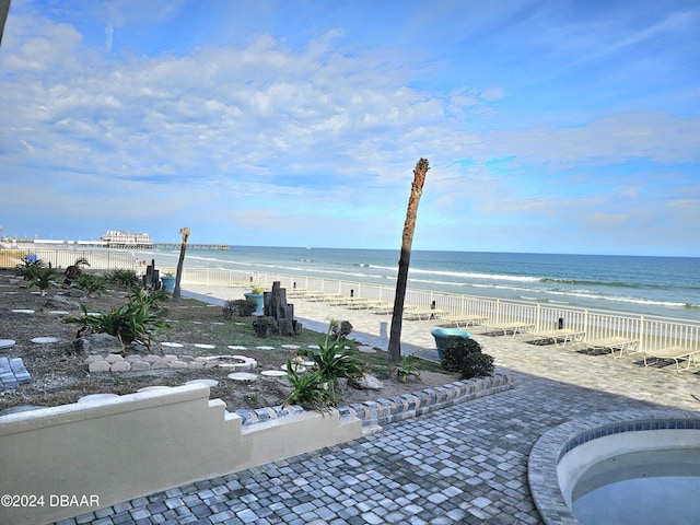 view of water feature featuring a beach view and fence