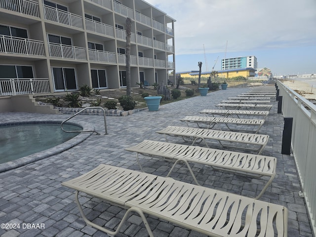 surrounding community with a pool and a patio area