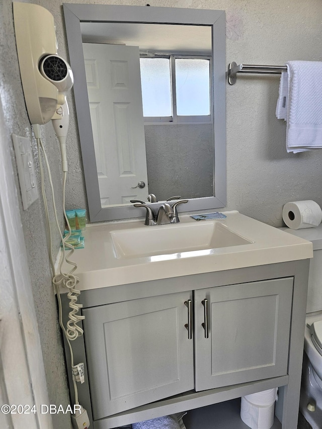 bathroom featuring a textured wall and vanity