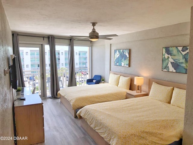 bedroom with light wood-type flooring, a ceiling fan, and access to exterior