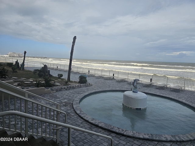 exterior space featuring fence, a view of the beach, and a water view