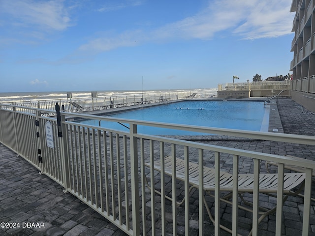 view of swimming pool featuring a water view