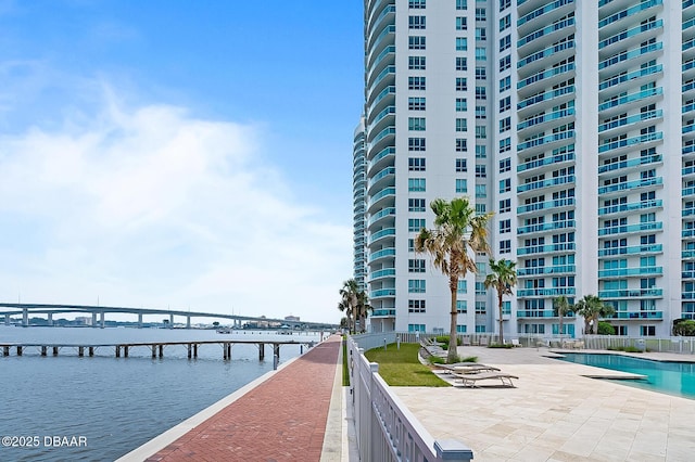 view of dock with a community pool and a water view