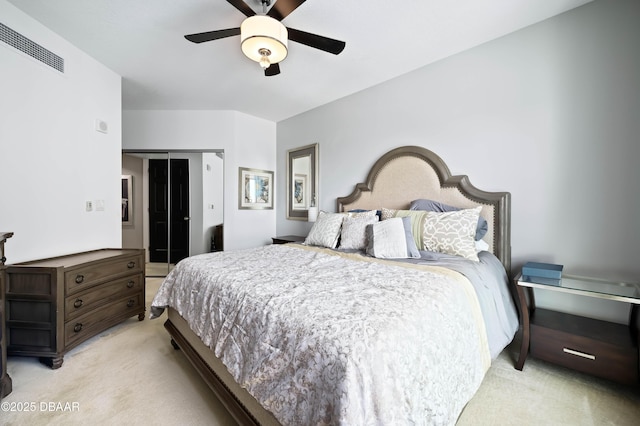 bedroom with a closet, visible vents, light colored carpet, and a ceiling fan