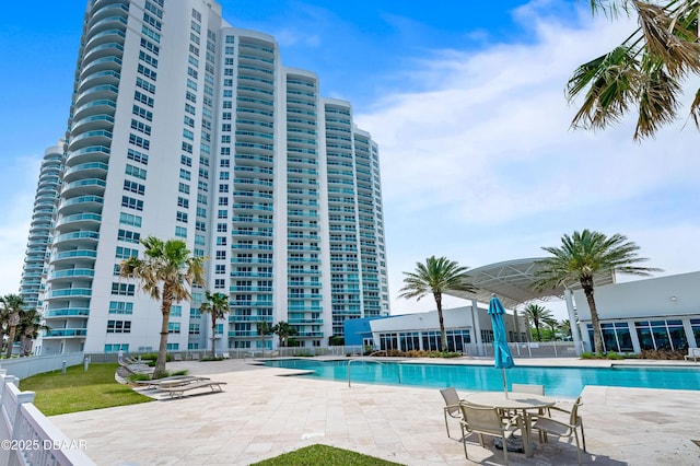 community pool with a patio area and fence