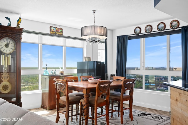 dining space featuring baseboards and an inviting chandelier