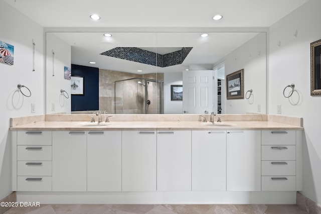 bathroom with recessed lighting, double vanity, a sink, and a stall shower