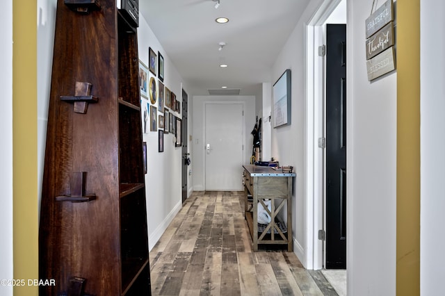 hallway featuring recessed lighting, baseboards, and hardwood / wood-style floors