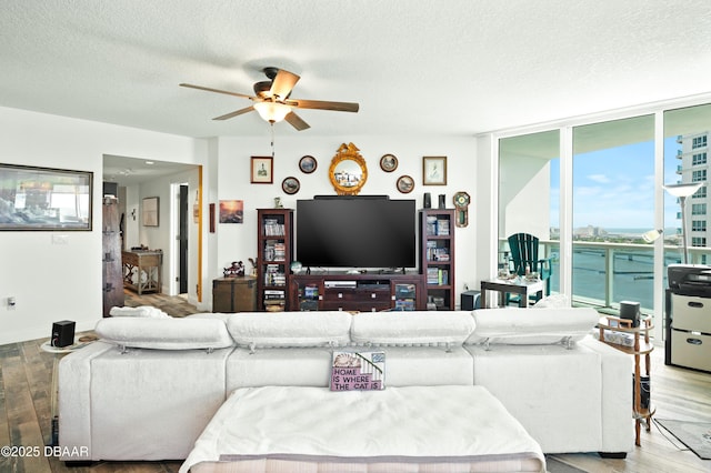 living room with floor to ceiling windows, a textured ceiling, wood finished floors, and ceiling fan