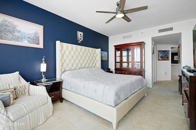 bedroom with light colored carpet, ceiling fan, and visible vents