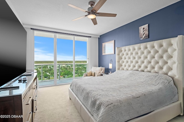 bedroom with a wall of windows, carpet flooring, ceiling fan, and a textured ceiling