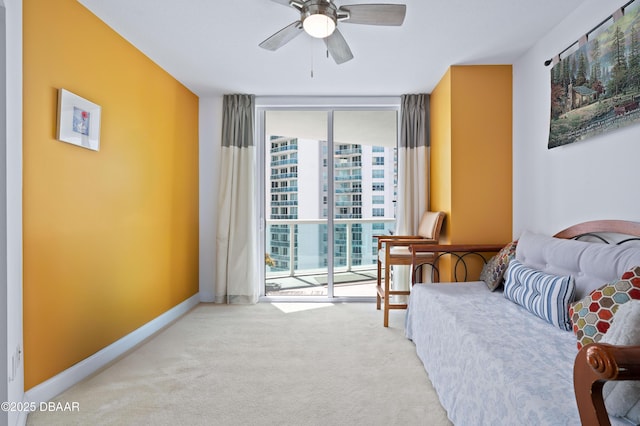 living area with floor to ceiling windows, baseboards, a ceiling fan, and carpet floors