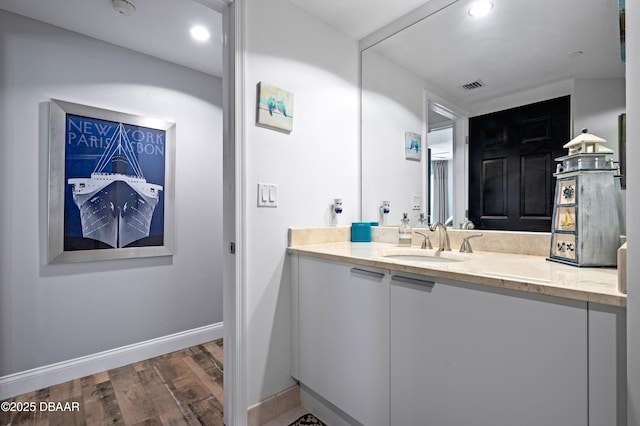 bathroom featuring visible vents, baseboards, recessed lighting, vanity, and wood finished floors