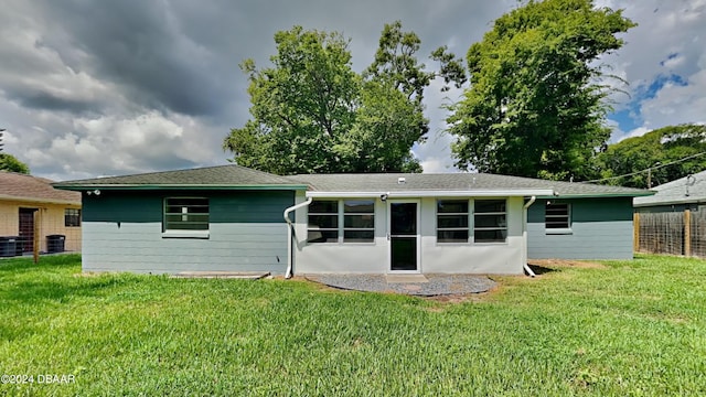 back of house featuring a yard and central AC