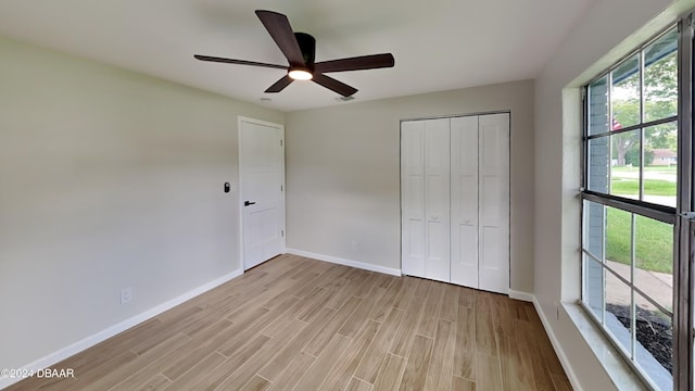 unfurnished bedroom featuring ceiling fan, a closet, and light wood-type flooring