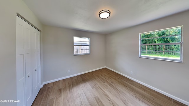 unfurnished bedroom featuring light hardwood / wood-style floors and a closet