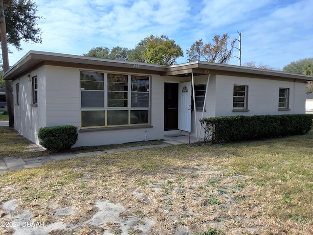 single story home featuring a front lawn