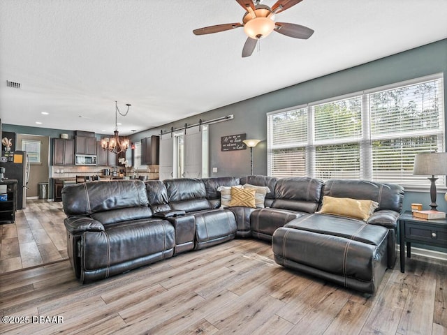 19 Abacus Ave, Ormond Beach, FL 32174 - living area featuring a barn door, light wood-style floors, a chandelier, ceiling fan, and recessed lighting