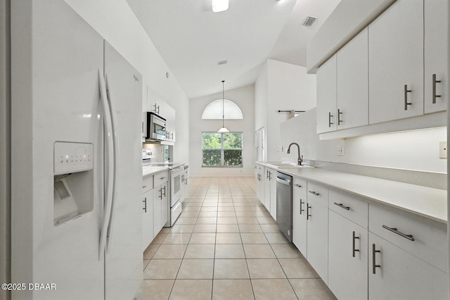 918 Brookridge Ln, Ormond Beach, FL 32174 - kitchen with stainless steel appliances, white cabinets, high vaulted ceiling, light countertops, and light tile patterned floors