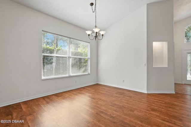 918 Brookridge Ln, Ormond Beach, FL 32174 - spare room featuring wood finished floors, a chandelier, and vaulted ceiling