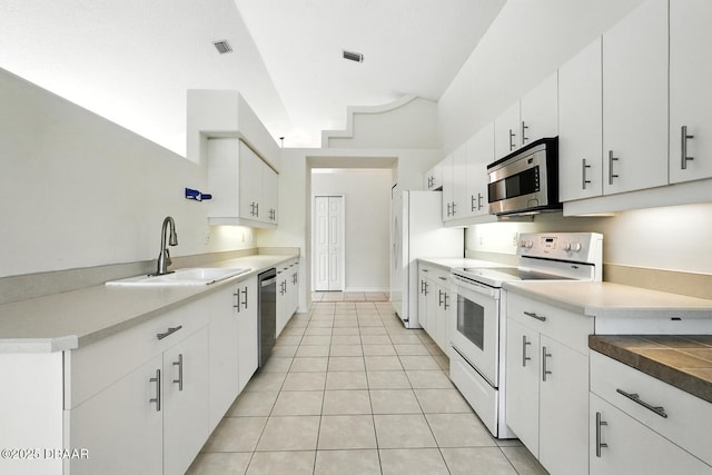 918 Brookridge Ln, Ormond Beach, FL 32174 - kitchen featuring appliances with stainless steel finishes, light tile patterned floors, white cabinets, and light countertops