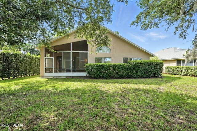 918 Brookridge Ln, Ormond Beach, FL 32174 - back of property featuring a sunroom, a yard, and stucco siding