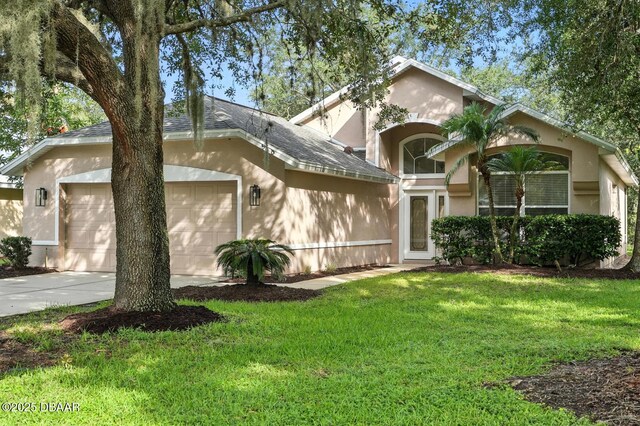 918 Brookridge Ln, Ormond Beach, FL 32174 - view of front of property with stucco siding, a garage, a front yard, driveway, and a shingled roof