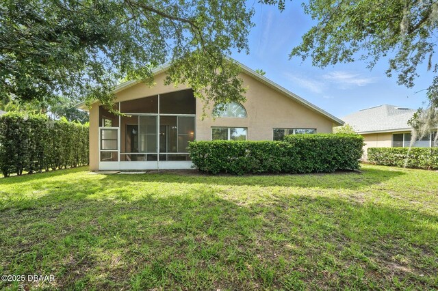 918 Brookridge Ln, Ormond Beach, FL 32174 - back of property featuring a sunroom, a yard, and stucco siding