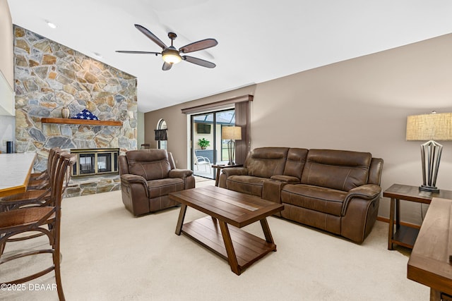 carpeted living room with ceiling fan and a fireplace