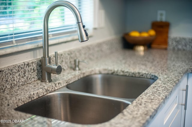 2 Springwood Sq, Port Orange, FL 32129 - kitchen view of a sink, light stone countertops, and white cabinetry