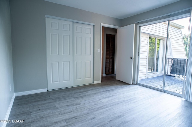 2 Springwood Sq, Port Orange, FL 32129 - unfurnished bedroom featuring access to exterior, wood finished floors, baseboards, and a closet