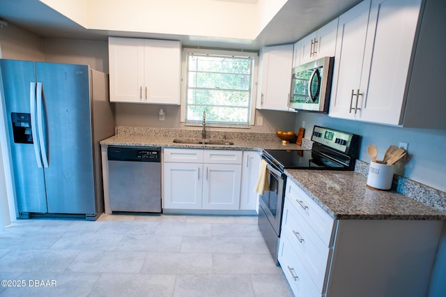 2 Springwood Sq, Port Orange, FL 32129 - kitchen with appliances with stainless steel finishes, a sink, stone countertops, and white cabinetry