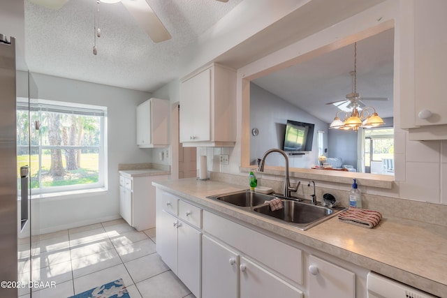 kitchen featuring a wealth of natural light, light tile patterned floors, light countertops, and a sink