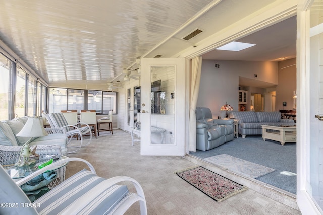 sunroom with lofted ceiling with skylight and visible vents