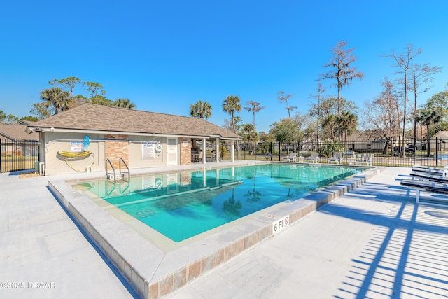 community pool featuring a patio and fence