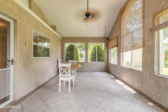 121 Palm Dr, Daytona Beach, FL 32117 - sunroom / solarium featuring plenty of natural light, tile patterned flooring, ceiling fan, a textured wall, and high vaulted ceiling