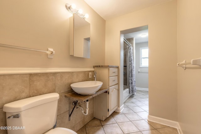 121 Palm Dr, Daytona Beach, FL 32117 - bathroom featuring toilet, tile patterned floors, a sink, shower / tub combo with curtain, and tile walls