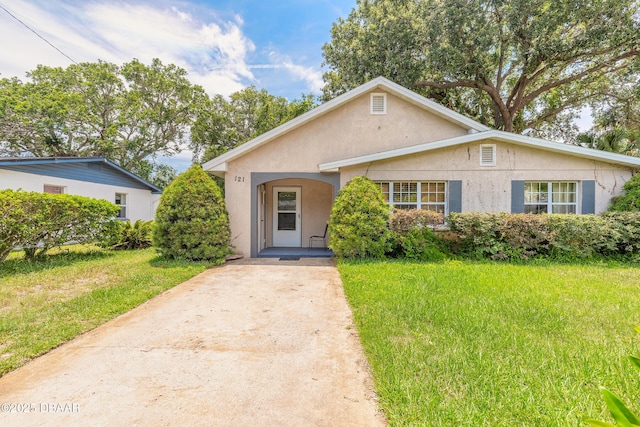 121 Palm Dr, Daytona Beach, FL 32117 - bungalow-style house featuring stucco siding, driveway, and a front yard
