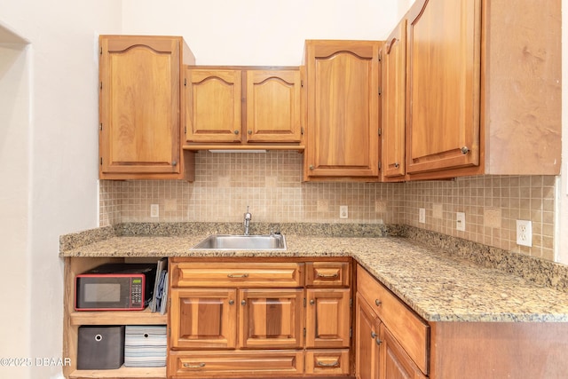 121 Palm Dr, Daytona Beach, FL 32117 - kitchen with black microwave, a sink, backsplash, and light stone countertops
