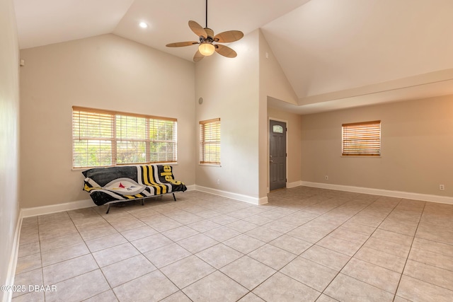 121 Palm Dr, Daytona Beach, FL 32117 - empty room featuring light tile patterned floors, healthy amount of natural light, ceiling fan, baseboards, and high vaulted ceiling