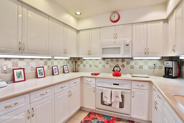 kitchen with white cabinets, white appliances, light tile patterned flooring, and tasteful backsplash