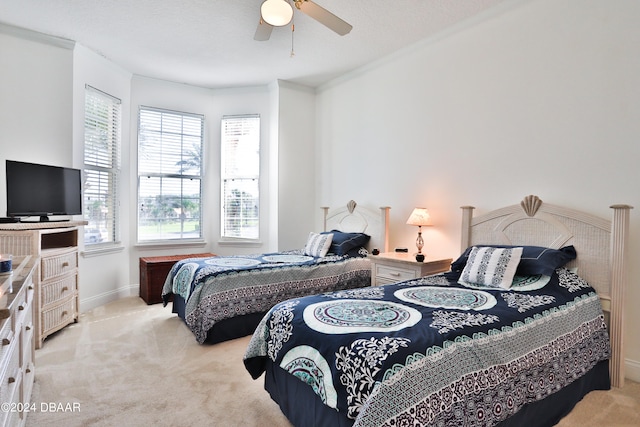 carpeted bedroom with a textured ceiling, ceiling fan, and crown molding