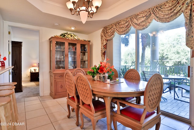 tiled dining space featuring a tray ceiling, a notable chandelier, and ornamental molding