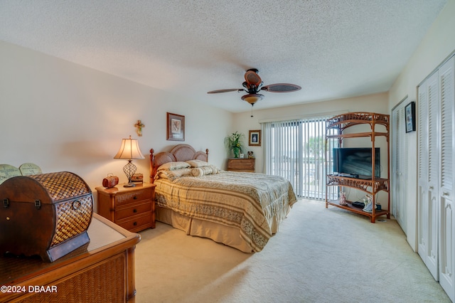 carpeted bedroom featuring a textured ceiling, ceiling fan, and a closet